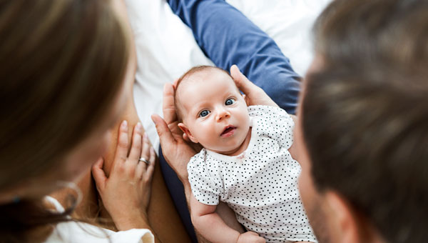 Parents holding their recent born baby.